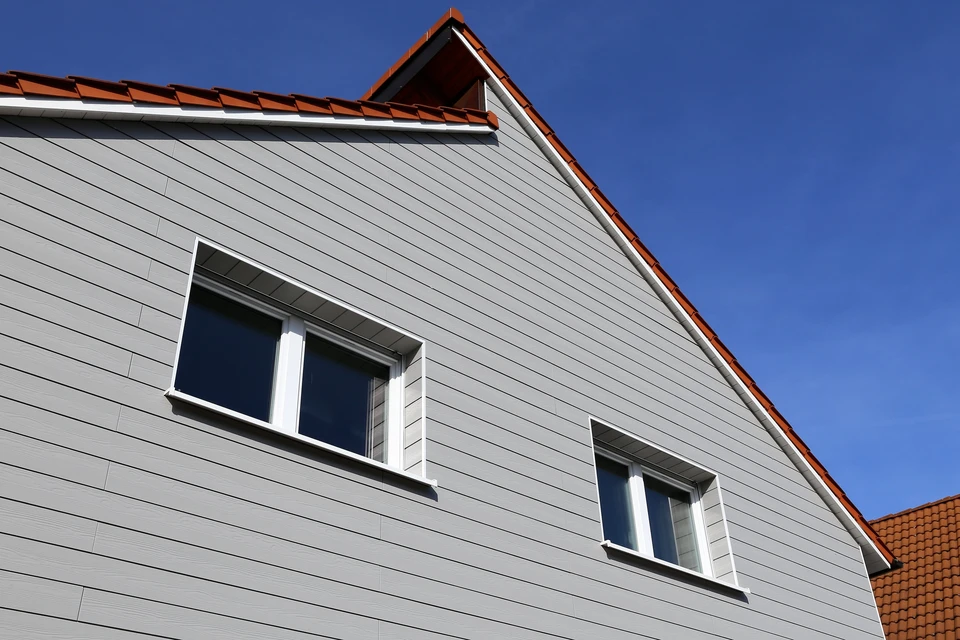 Façade extérieure en bardage bois vertical, lames de bois naturel disposées parallèlement avec joints creux réguliers