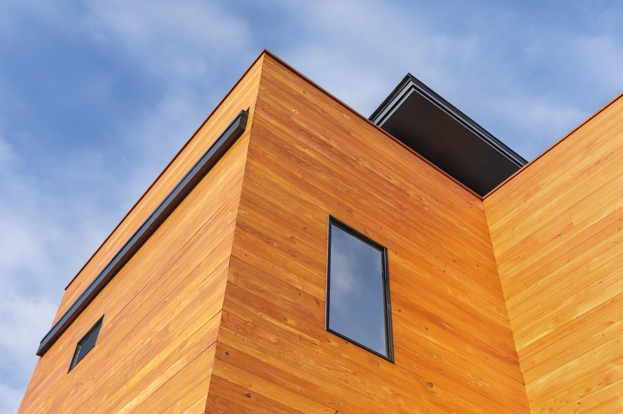 Façade extérieure d'un bâtiment résidentiel moderne avec bardage bois horizontal de couleur naturelle claire