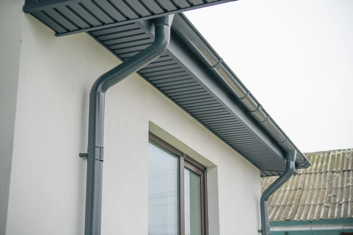 Chantier de construction résidentielle en cours avec charpente bois apparente et échafaudage métallique