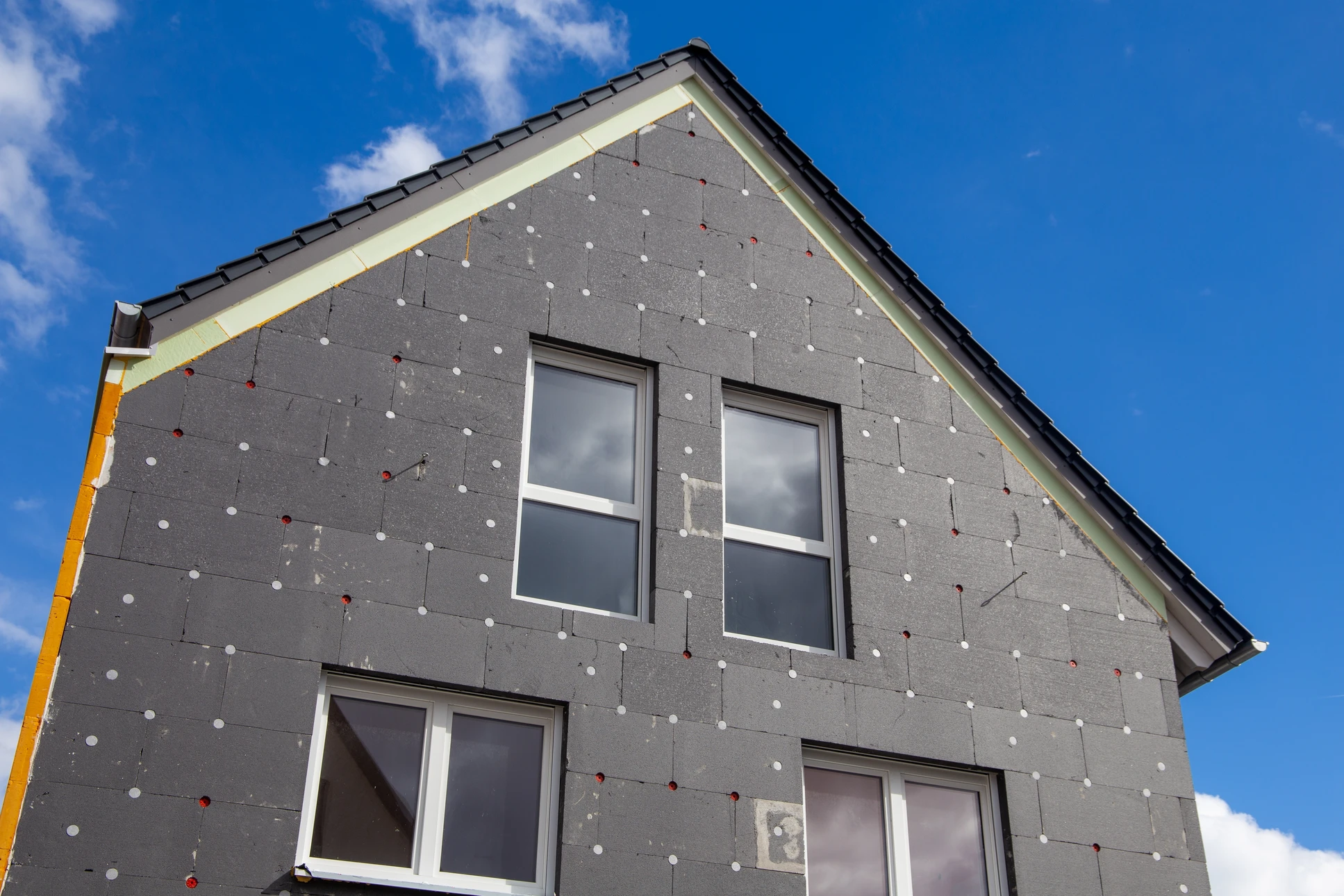 Chantier de rénovation extérieure d'une habitation avec travaux d'isolation thermique par l'extérieur en cours